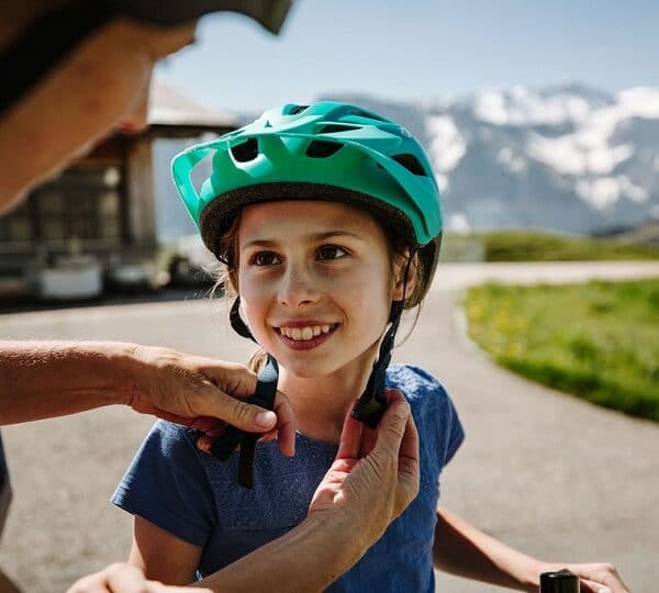 Vater hilft der Tochter beim Helm anziehen